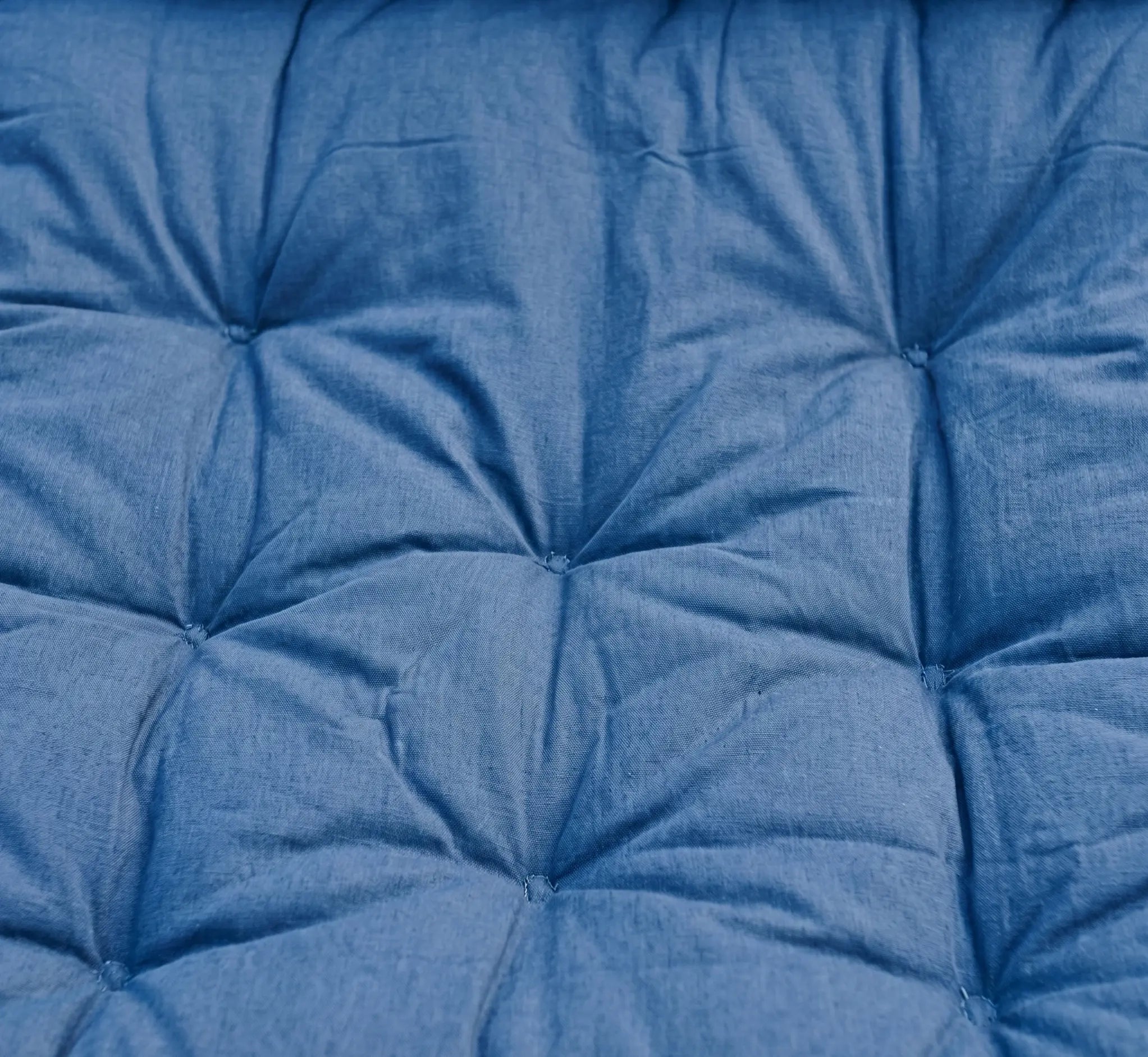 Vue de face d'une chaise hamac suspendue en tissu de coton tissé épais. Le tissu présente des rayures verticales vives aux couleurs variées : bleu turquoise, orange, rouge, crème et bleu marine. Elle est suspendue par un assemblage de cordes blanches en macramé avec des détails de perles en bois, reliées à une barre d'écartement en bois brut et un mousqueton métallique. Isolé sur un fond blanc pour un rendu produit clair et détaillé.