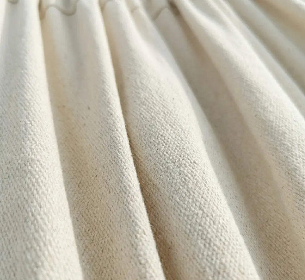 Gros plan sur les finitions artisanales et les cordes de suspension en coton écru naturel d'un hamac brésilien haut de gamme.