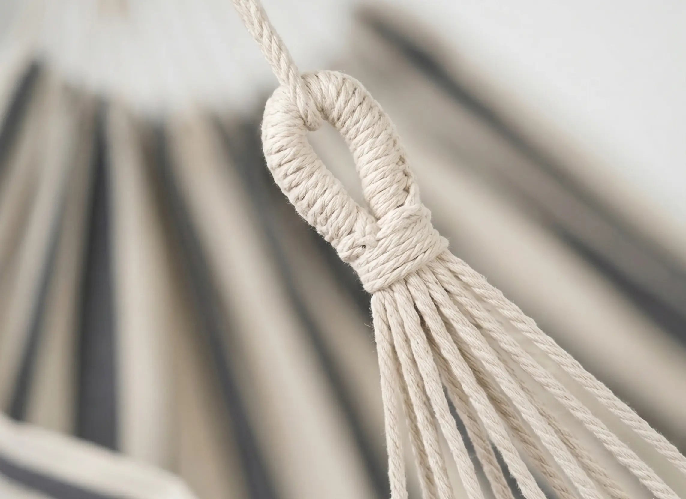 Gros plan sur la boucle de suspension renforcée et les cordes tressées en coton d'un hamac brésilien haut de gamme.