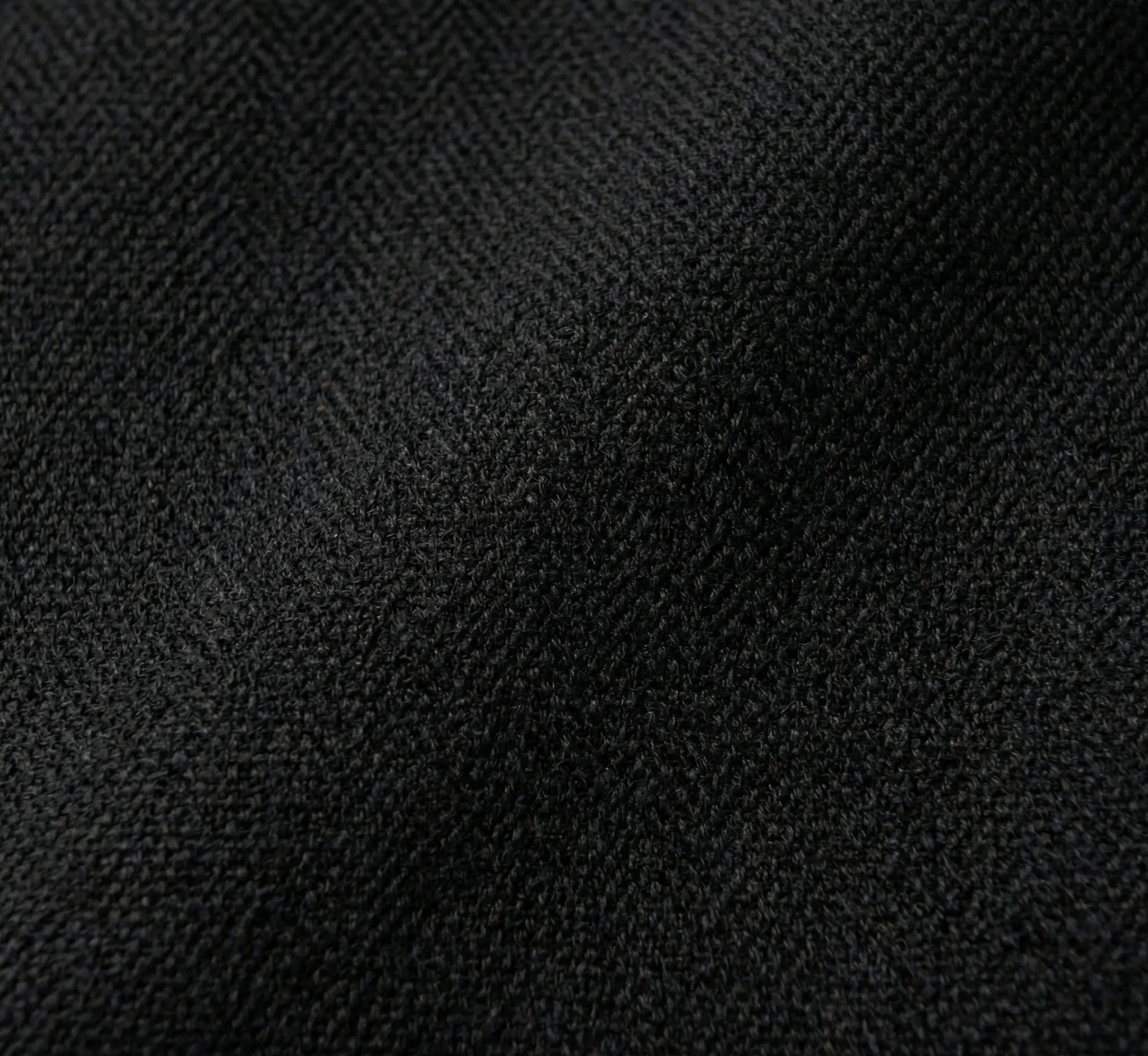 Gros plan sur les franges délicates en macramé tressées à la main et les pompons décoratifs d'un hamac de luxe en coton noir intense.