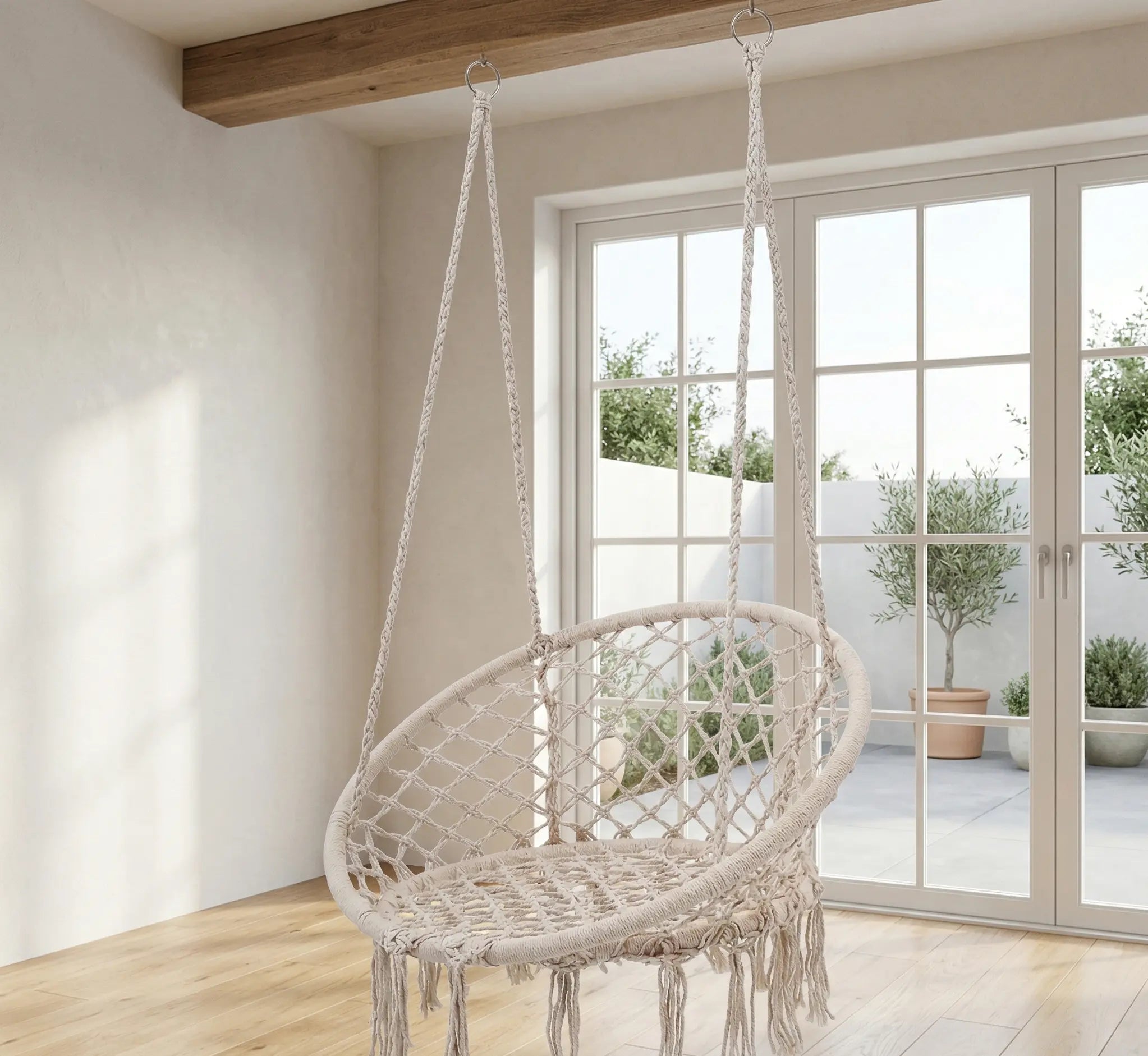 Balancelle ronde en macramé beige avec franges artisanales suspendue dans une chambre d'enfant/adolescent de style bohème avec parquet en bois et décoration douce