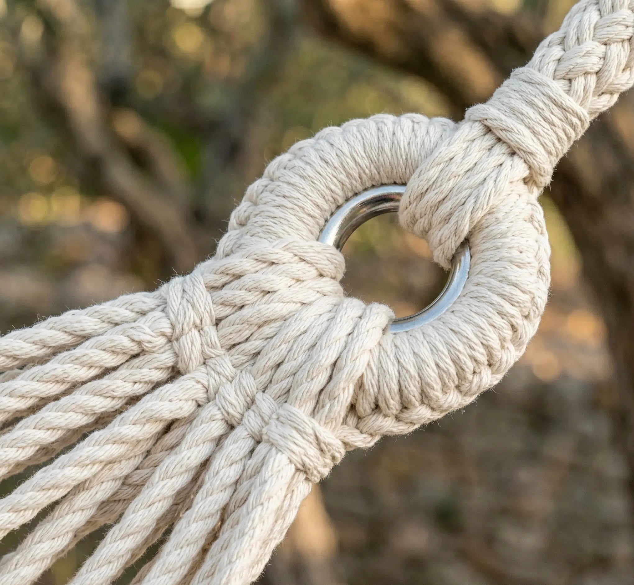 Zoom sur l'œillet de suspension en acier inoxydable et le tressage renforcé en corde de coton d'un hamac artisanal.