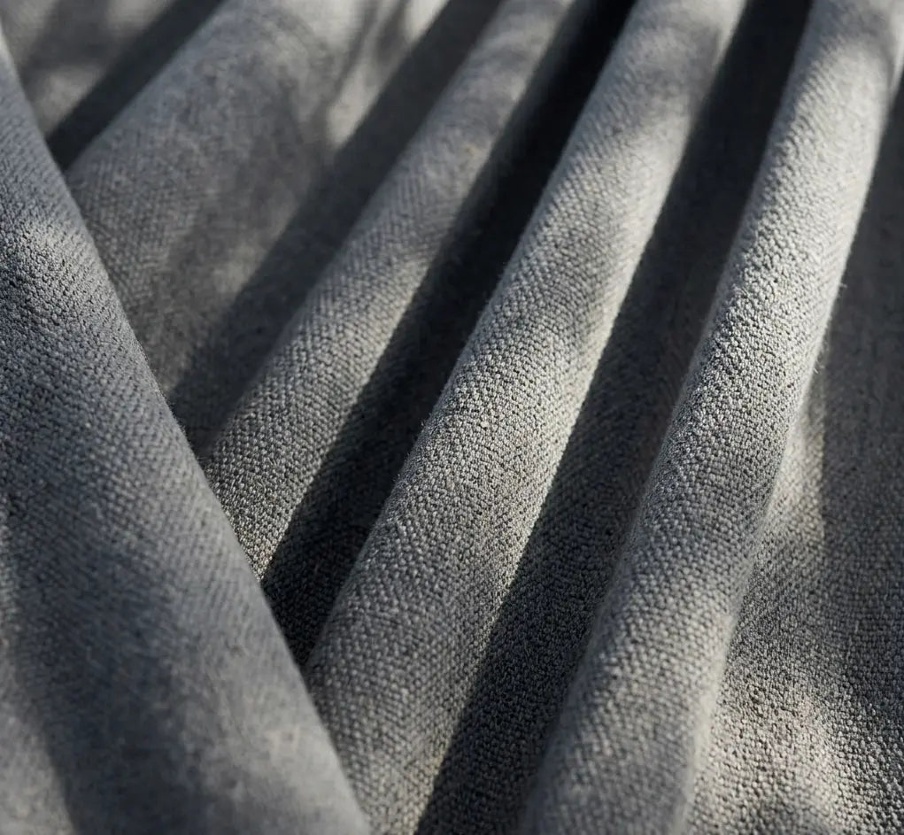 Gros plan sur le tissage dense et la texture douce d'une toile de hamac en pur coton gris anthracite de haute qualité.