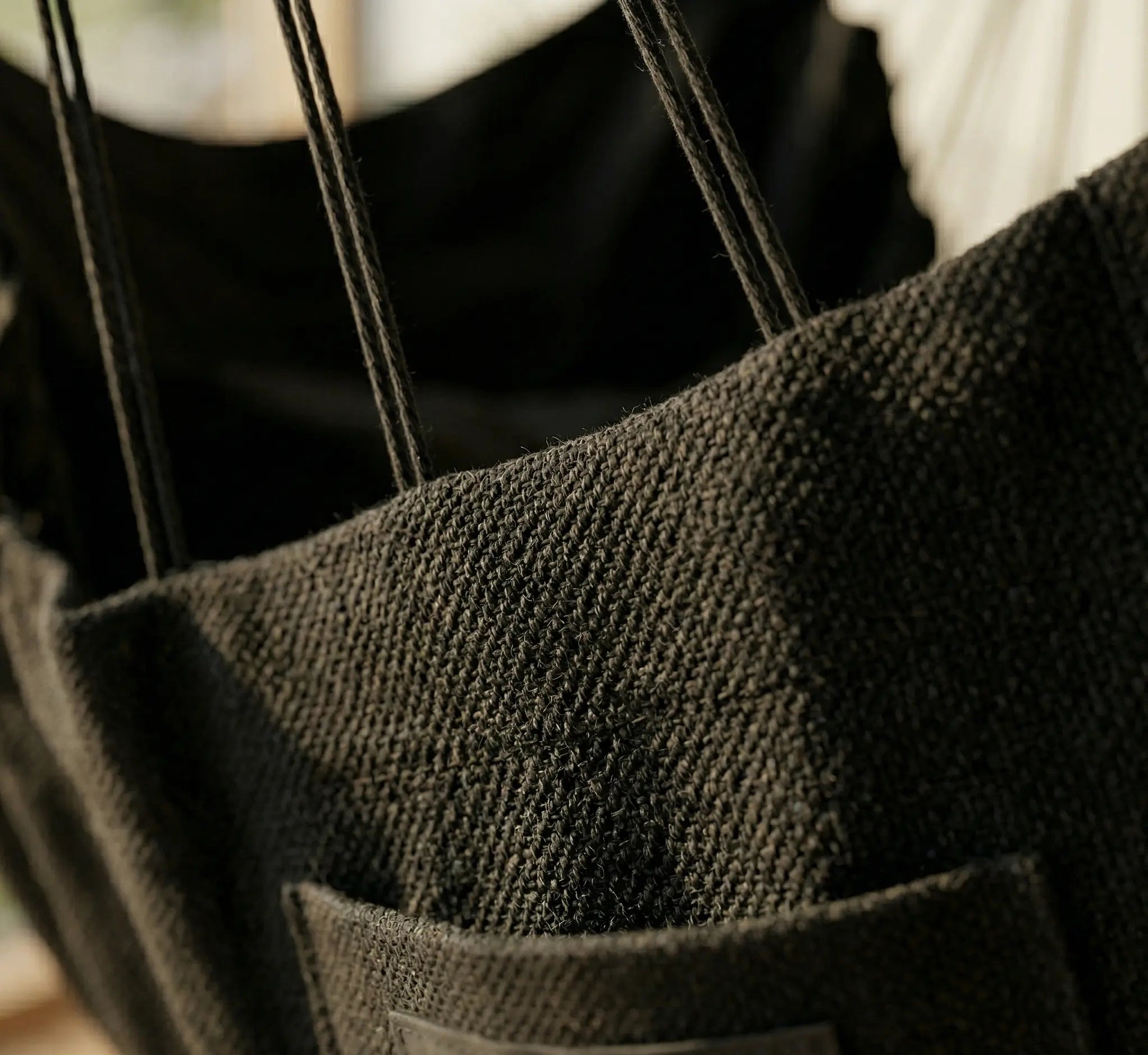 Gros plan sur le tissage serré d'une chaise hamac noire en coton renforcé montrant la texture du tissu et une poche de rangement latérale intégrée