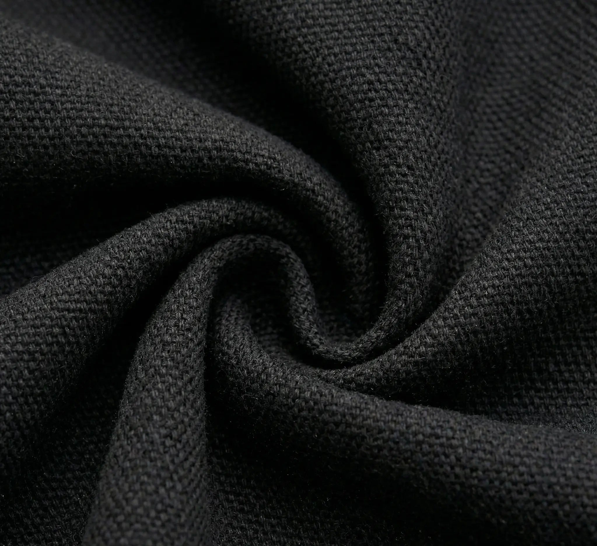 Vue macro du grain de tissage d'une toile de hamac en coton noir de haute densité montrant la qualité des fibres et la profondeur du coloris anthracite