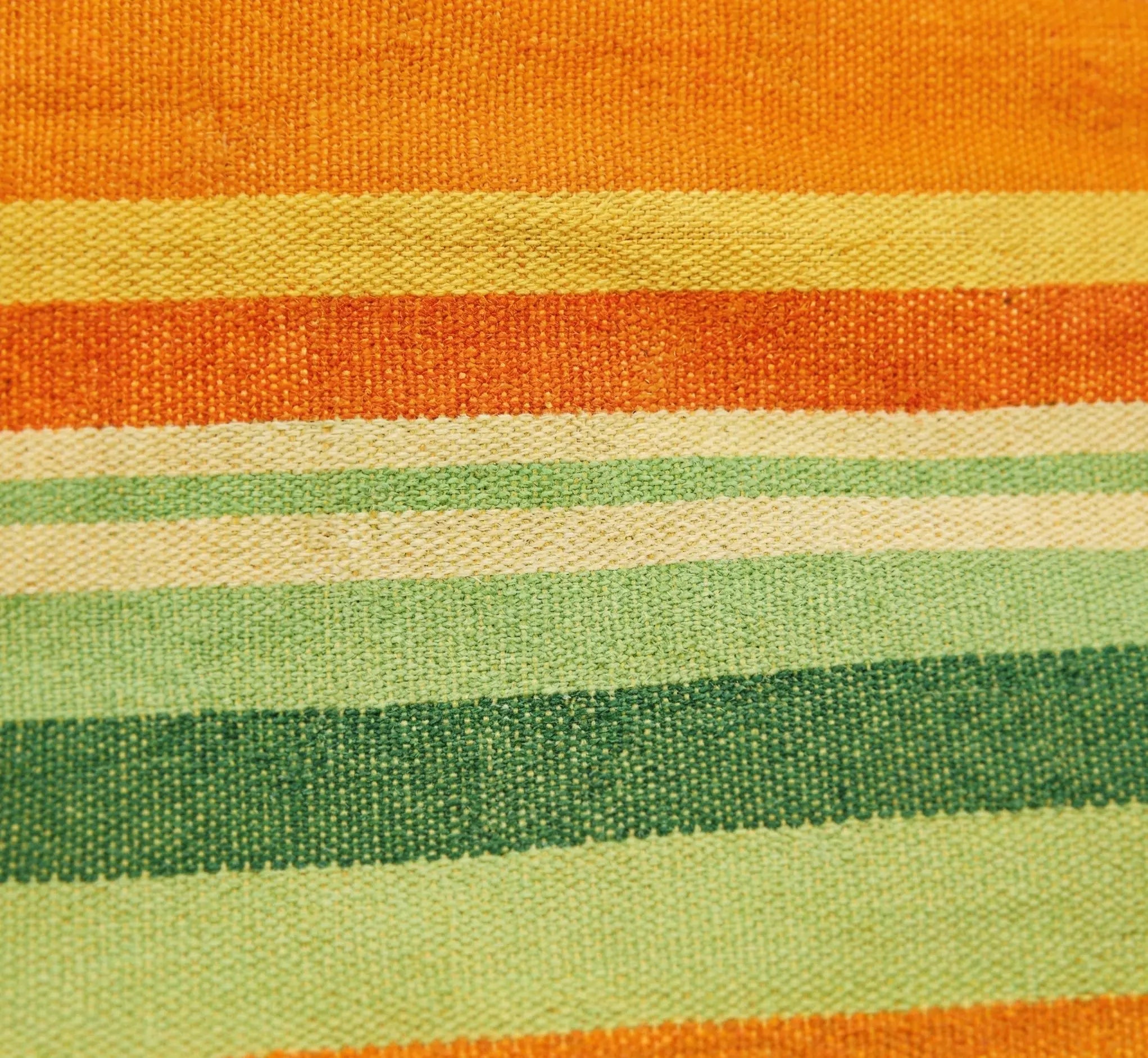 Gros plan macro sur le tissage serré d'une toile de hamac premium montrant les rayures en dégradé orange, jaune soleil et vert forêt en coton naturel haute densité