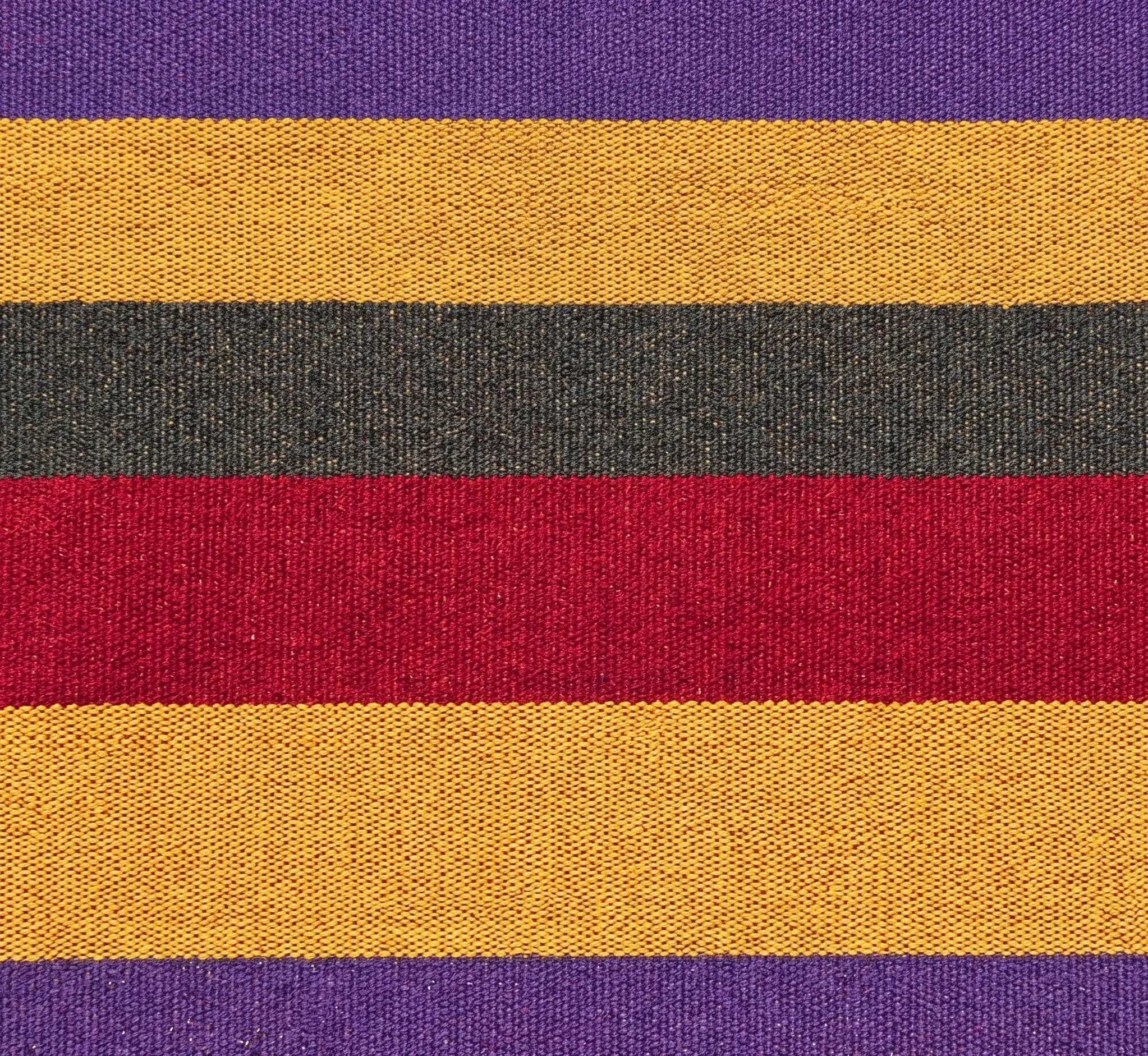 Très gros plan sur le tissage serré d'une toile de hamac en coton, montrant des rayures horizontales aux couleurs vibrantes : violet, jaune ocre, gris anthracite et rouge profond.