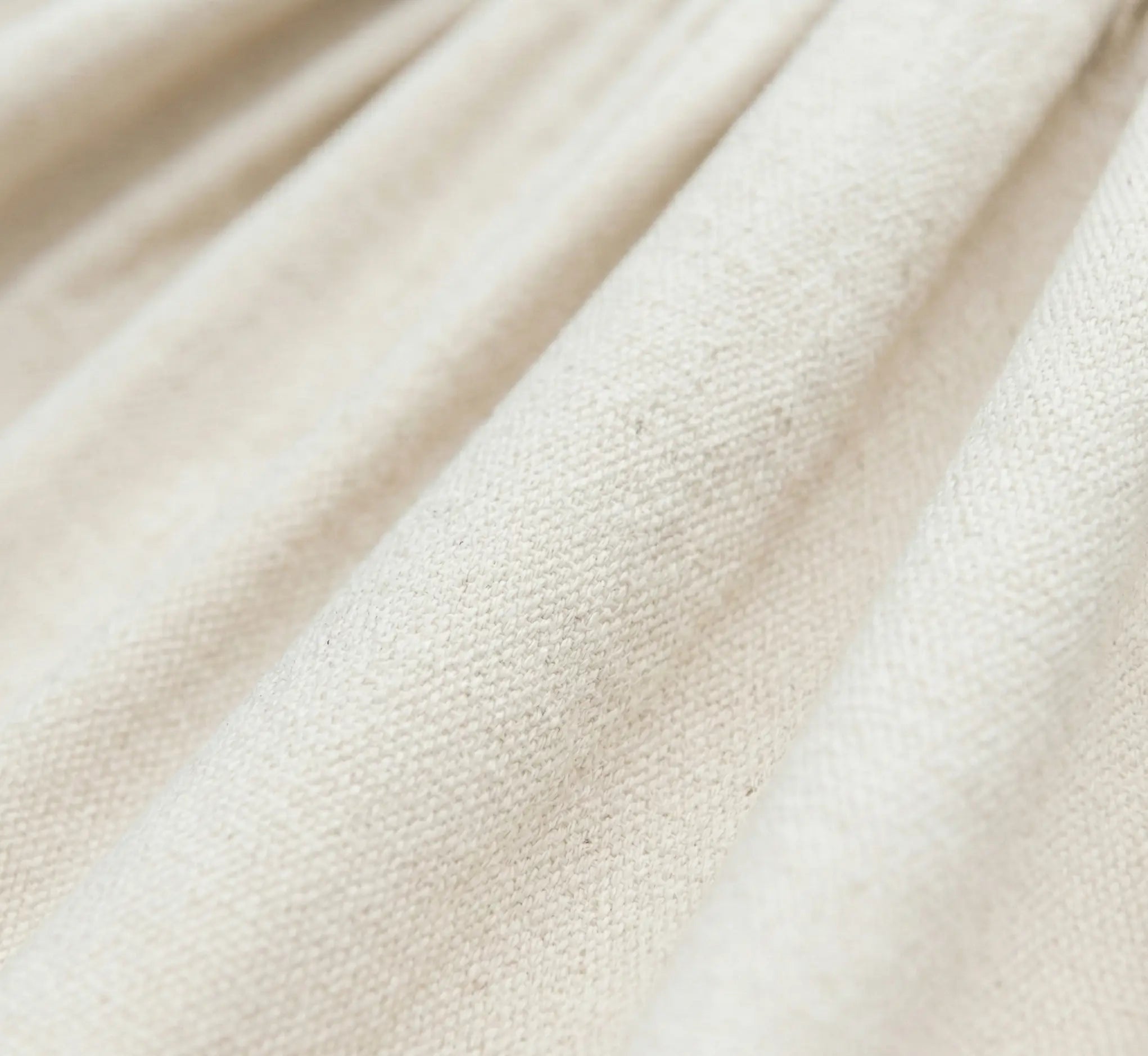 Vue macro du tissage serré d'un hamac en coton naturel blanc crème montrant la texture douce et résistante d'une toile haut de gamme