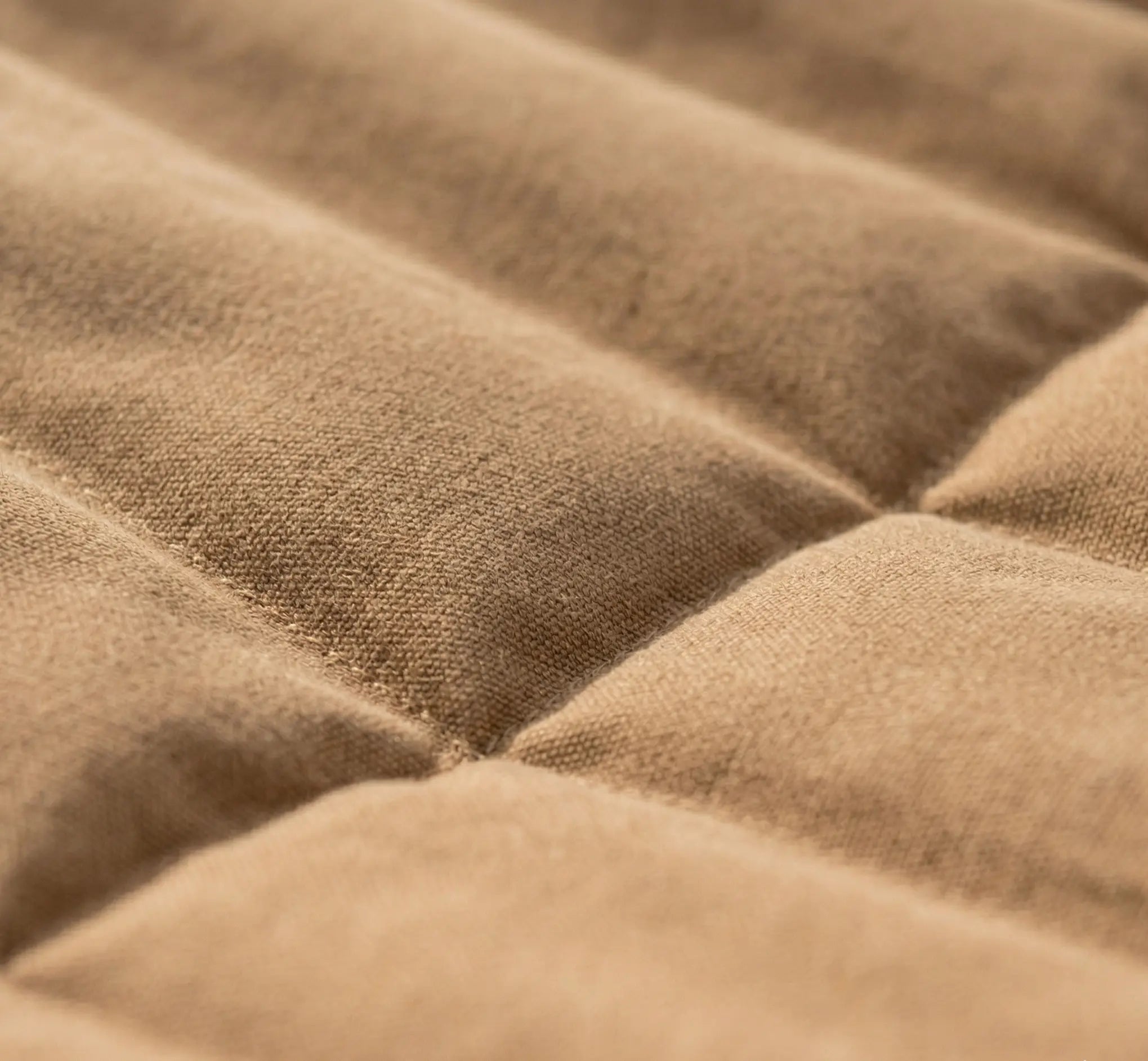 Gros plan macro sur le rembourrage capitonné d'une toile de hamac moka haut de gamme montrant la texture moelleuse et le tissage résistant du coton